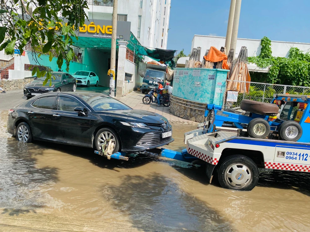 Do nước ngập, một số phương tiện không thể di chuyển phải nhờ xe cứu hộ. Ảnh: HUỲNH THƠ