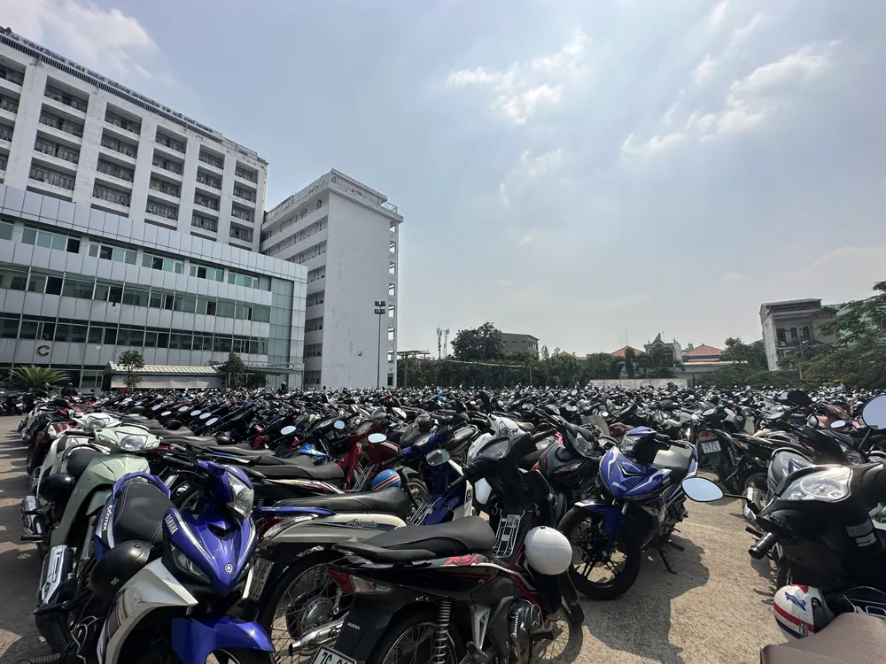 Vì diện tích trường khá nhỏ, nên đã tận dụng sân để xe làm sân đa năng cho sinh viên sinh hoạt thể dục, thể thao. Vì vậy sân không có mái che khiến xe phải để ngoài trời, dễ gây hư hỏng, cháy nổ. Ảnh: HT