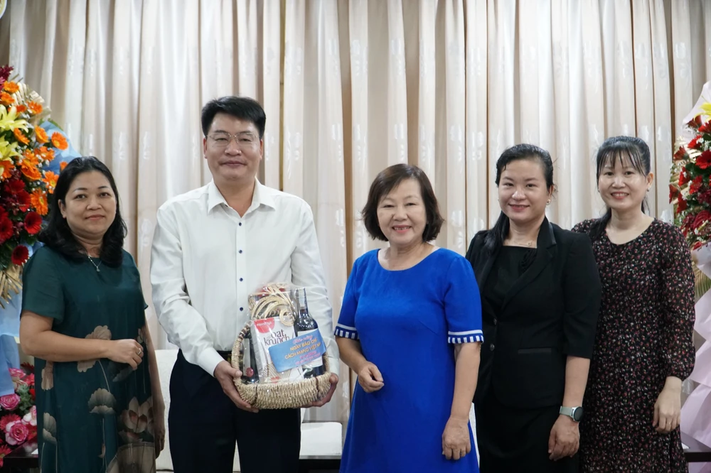 Bà Tô Thị Kim Hoa, Phó Chủ tịch Hội Bảo vệ quyền trẻ em TP.HCM tặng quà chúc mừng báo Pháp Luật TP.HCM. Ảnh: NHẬT DIỄM