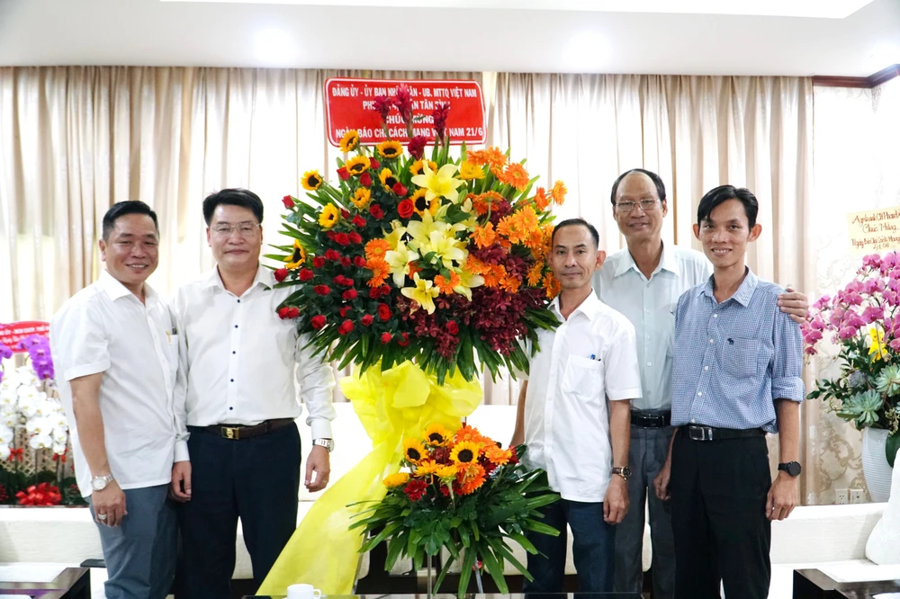 Đại diện Quận uỷ, UBND, Ủy ban MTTQ Việt Nam phường 4, quận Tân Bình tặng hoa cho báo Pháp Luật TP.HCM. Ảnh: NHẬT DIỄM