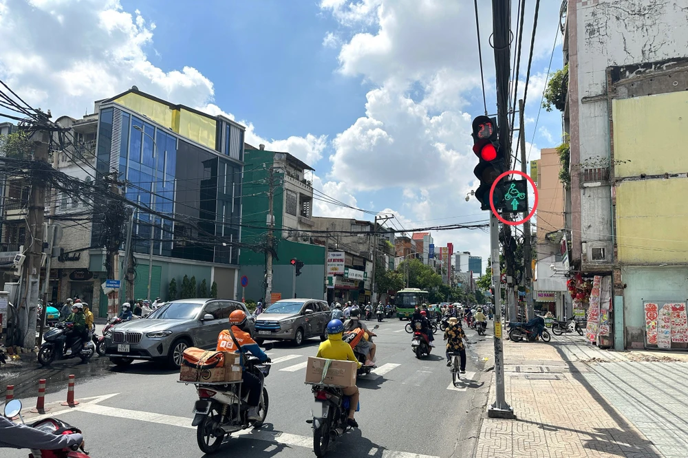 Khi gặp đèn đỏ nhưng cạnh bên có đèn tín hiệu cho phép đi thẳng thì xe máy có quyền đi thẳng. Ảnh: HUỲNH THƠ