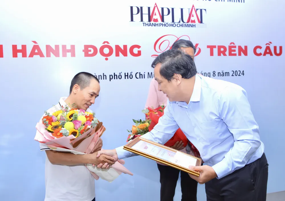 Ông Nguyễn Thái Bình, Phó Tổng Biên tập Báo Pháp Luật TP.HCM trao hoa và quà cho anh Nguyễn Hoàng Trường. Ảnh: NGUYỆT NHI 5.jpg