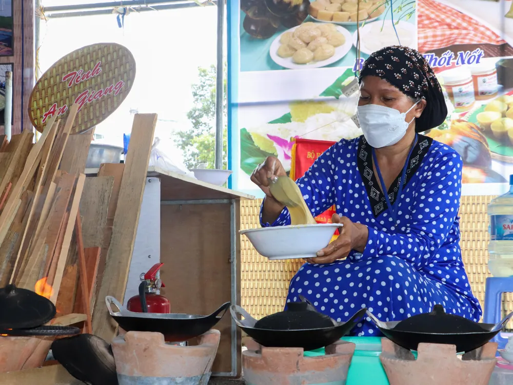 Nghệ nhân Ro Fi Ah trình diễn cách làm bánh bò nướng của người Chăm ở An Giang. Ảnh: CHÂU ANH