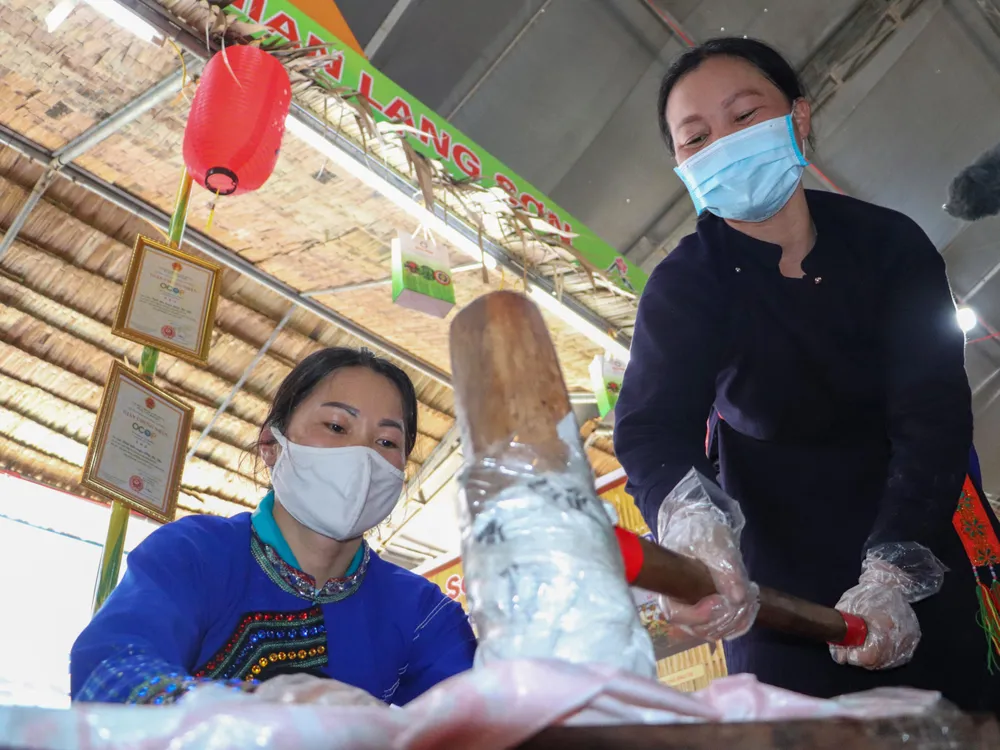 Nghệ nhân Hoàng Thị Yên trình diễn công đoạn giã (quết) bánh ngải trong cối của người Tày ở Lạng Sơn tại Lễ hội bánh. Ảnh: CHÂU ANH