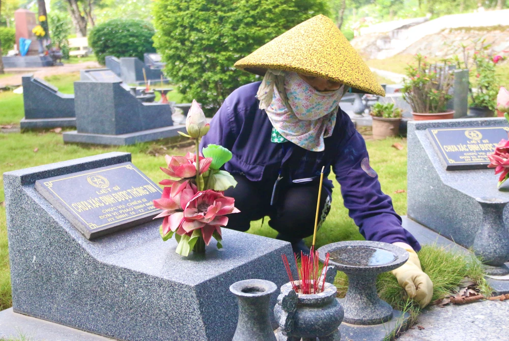 Bà Khiếu Thị Hanh làm công việc chăm sóc các ngôi mộ liệt sĩ đã 17 năm nay. Ảnh: THẢO PHƯƠNG