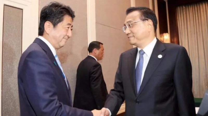 Thủ tướng Nhật Shinzo Abe (trái) và Thủ tướng Trung Quốc Lý Khắc Cường gặp nhau bên lề hội nghị Á-Âu tại Mông Cổ ngày 15-7.