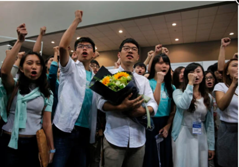Nathan Law (cầm hoa) và lãnh đạo sinh viên Joshua Wong thuộc đảng Demosistō mừng chiến thắng ngày 5-9.