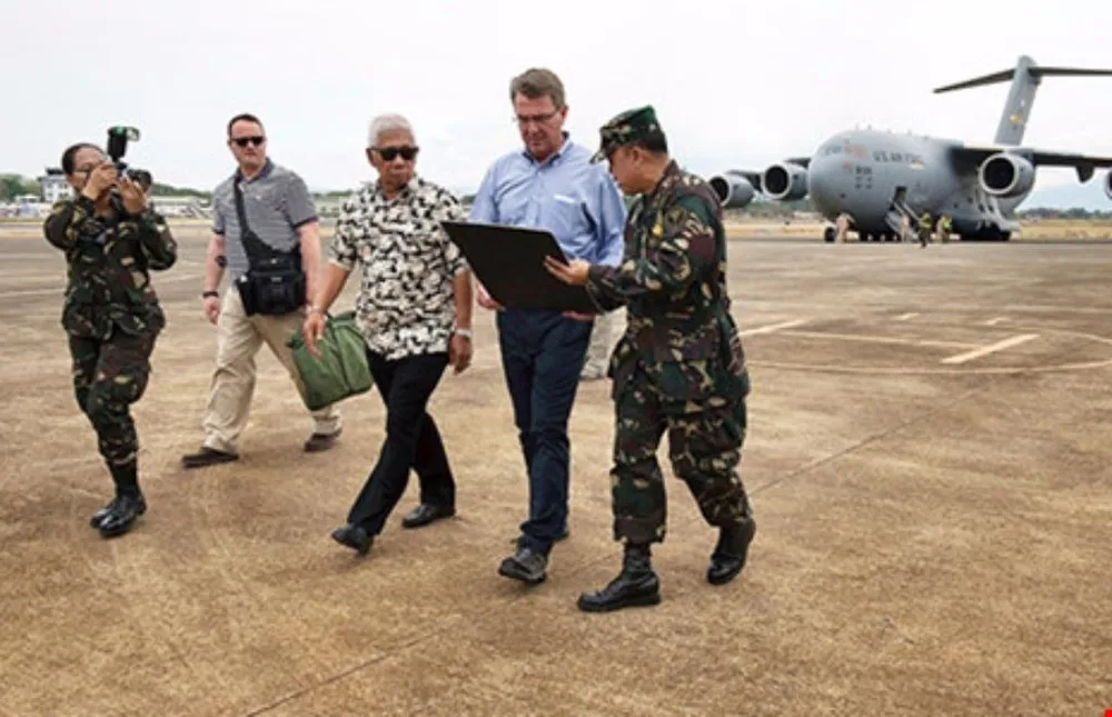 Bộ trưởng Quốc phòng Mỹ Ash Carter (thứ hai bên phải) và Bộ trưởng Quốc phòng Philippines Voltaire Gazmin tại sân bay Puerto Princesa (Philippines) trong chuyến thăm Philippines ngày 15-4. 