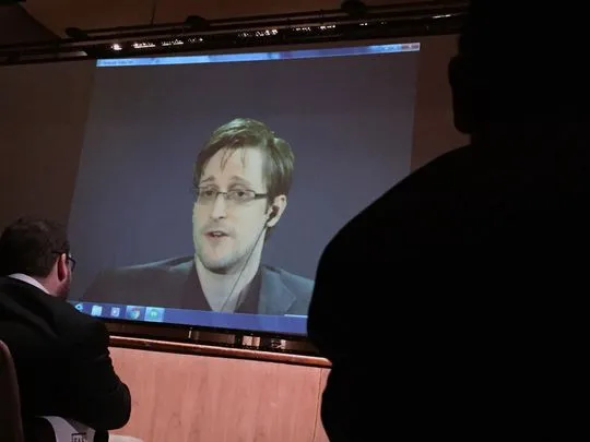 Edward Snowden (giữa) nói trong một hội nghị qua điện thoại với người Mỹ tại Johns Hopkins (Mỹ) ngày 17-2.