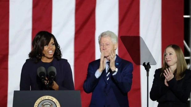 Đệ nhất phu nhân Michelle Obama cùng cựu Tổng thống Bill Clinton và cô Chelsea đứng trong làn kính chắn đạn trên sân khấu vận động cho bà Clinton tại Philadelphia ngày 7-11. 