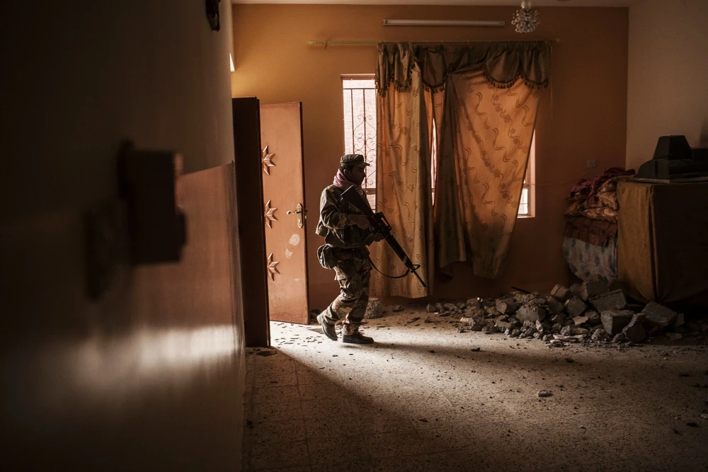 Lính Iraq soát tìm IS trong một ngôi nhà ở làng Al-Qasr, cách Mosul 7km, ngày 30-11. 