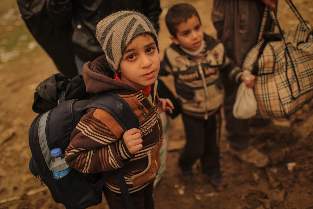 Trẻ em Mosul theo gia đình sơ tán. Đã có hơn 70.000 dân sơ tán khỏi Mosul trong 7 tuần qua. Ảnh: VICE