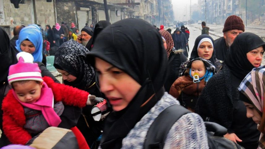 Người dân đến quận Fardo sau khi sơ tán khỏi quận Bustan al-Qasr (đông Aleppo) ngày 13-12. Ảnh: AFP