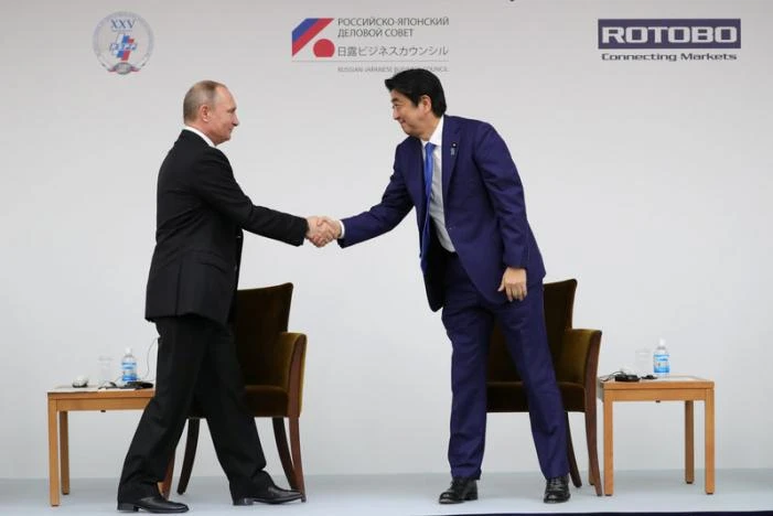 Tổng thống Putin (trái) bắt tay Thủ tướng Abe trong buổi đối thoại doanh nghiệp Nhật-Nga tại Tokyo (Nhật) ngày 16-12. Ảnh: REUTERS 