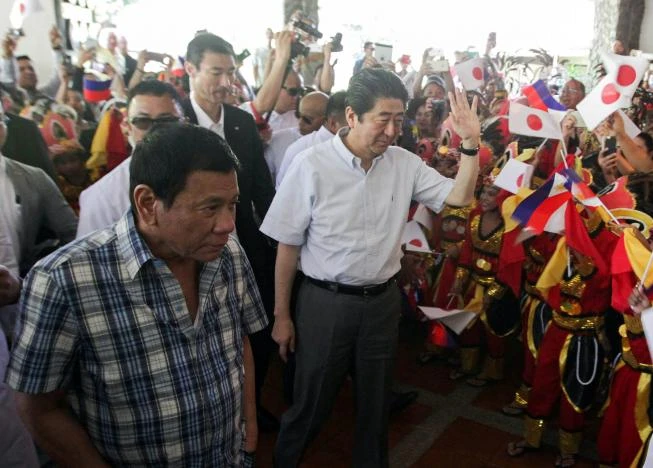 Tổng thống Duterte (trái) và Thủ tướng Abe gặp gỡ các vũ công dân gian trong một sự kiện tại Davao (Philippines) ngày 13-1. Ảnh: REUTERS