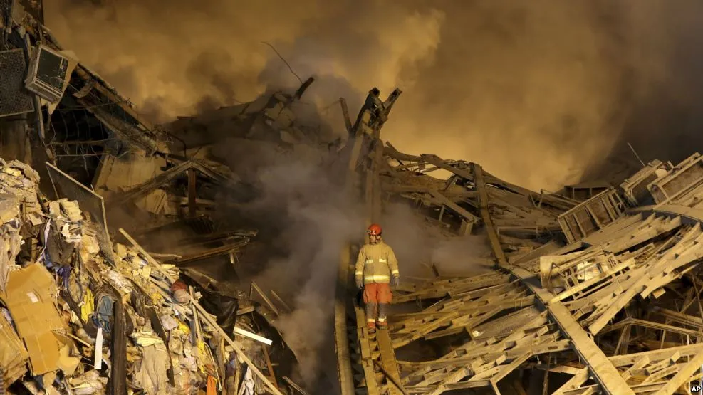 Lính cứu hỏa cố tìm đồng nghiệp trong đống đổ nát. Ảnh: AP