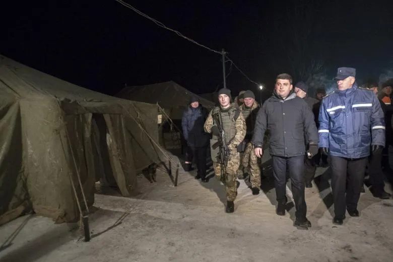 Thủ tướng Ukraine Volodymyr Groysman (áo đen) đến thị trấn Avdiyivka (đông Ukraine) ngày 31-1. Ảnh: REUTERS