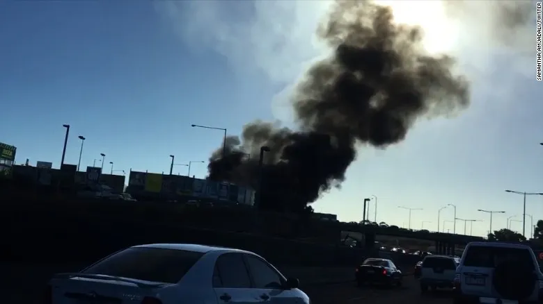 Máy bay rơi trúng trung tâm mua sắm Úc ảnh 2 Khói đen bốc lên cuồn cuộn sau khi máy bay rơi trên trung tâm mua sắm. Ảnh: BBC