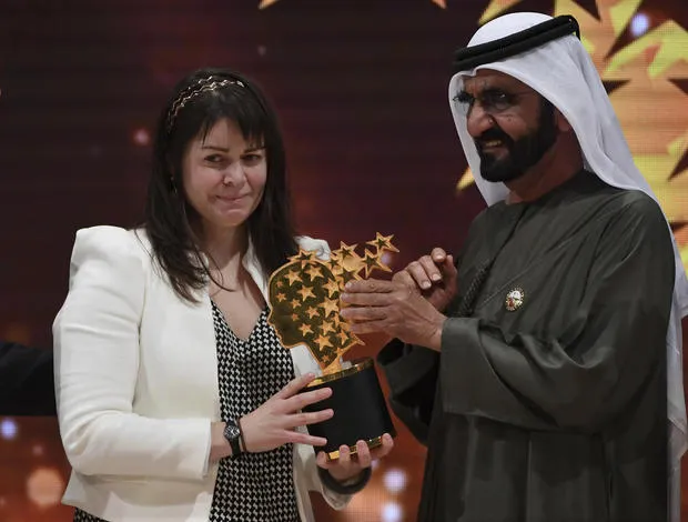 Cô giáo Maggie MacDonnell nhận giải từ Tiểu vương Dubai Mohammed bin Rashid Al Maktoum ngày 19-3. Ảnh: AP
