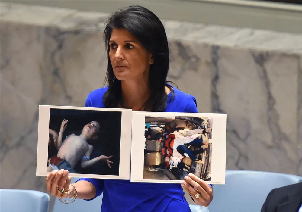 Đại sứ Mỹ tại LHQ Nikki Haley và những bức ảnh nạn nhân trong vụ đánh bom hóa học ở Syria ngày 4-4. Ảnh: AFP