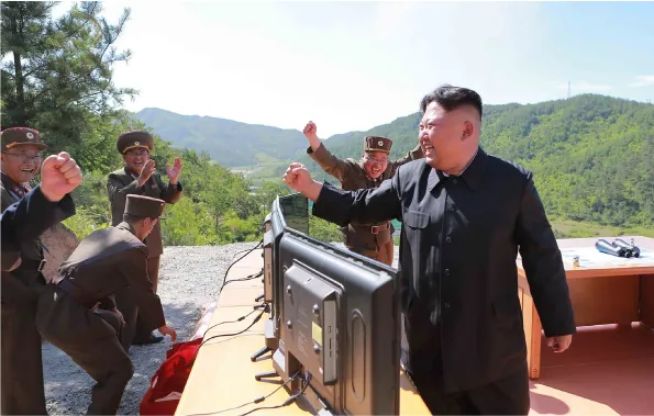 Lãnh đạo Triều Tiên Kim Jong-un (phải) sau khi giám sát vụ phóng tên lửa ICBM Hwasong-14 ngày 4-7. Ảnh: SCMP