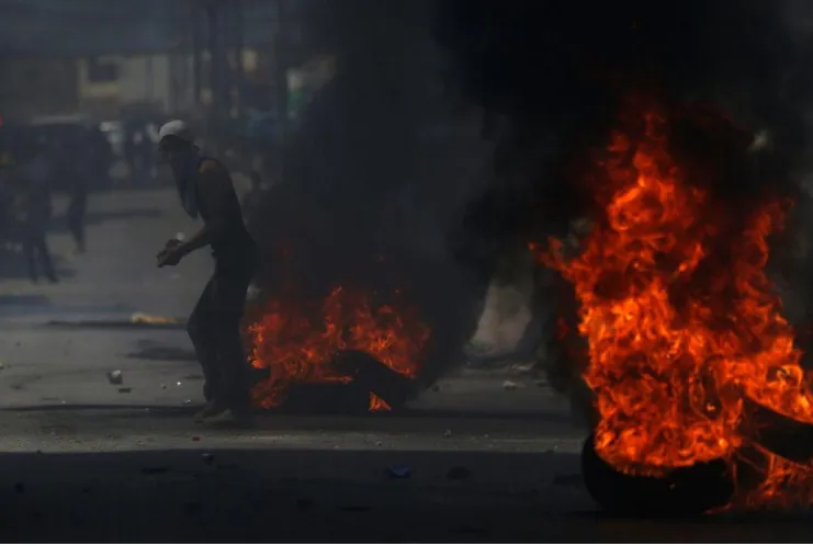 Người biểu tình Palestine xung đột với binh sĩ Israel gần chốt kiểm tra Qalandiya gần TP Ramallah ở Bờ Tây ngày 21-7. Ảnh: REUTERS
