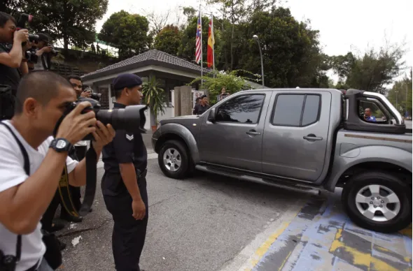 Xe chở hai nghi phạm đến tòa án ngày 28-7. Ảnh: AP