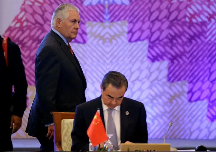 Ngoại trưởng Mỹ Rex Tillerson (trái) bước ngang qua bàn của Bộ trưởng Ngoại giao Trung Quốc Vương Nghị tại hội nghị Các Bộ trưởng Ngoại giao Đông Á và các đối tác ở Manila (Philippines) ngày 7-8. Ảnh: REUTERS