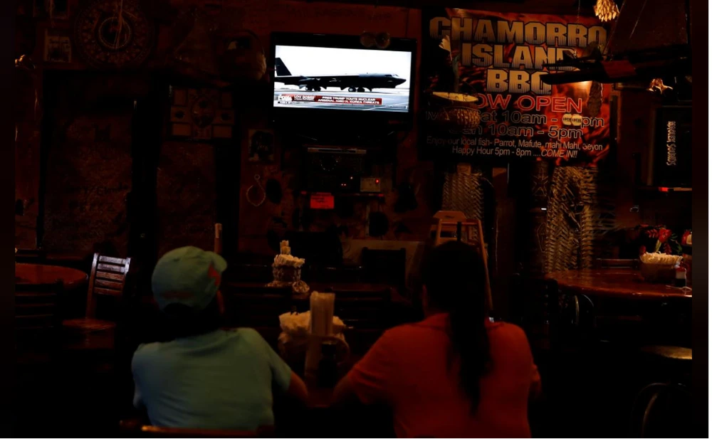 Dân đảo Guam theo dõi tin tức về khủng hoảng Triều Tiên qua truyền hình ngày 14-8. Ảnh: REUTERS