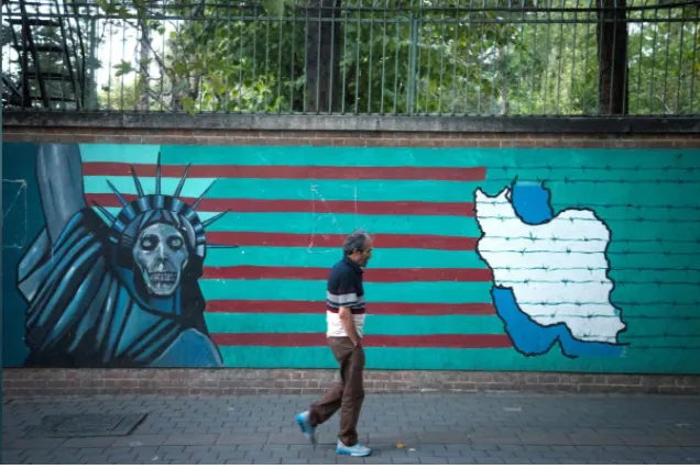 Người dân Iran bước ngang hình ảnh chống Mỹ ở Tehran (Iran) ngày 13-10. Ảnh: REUTERS