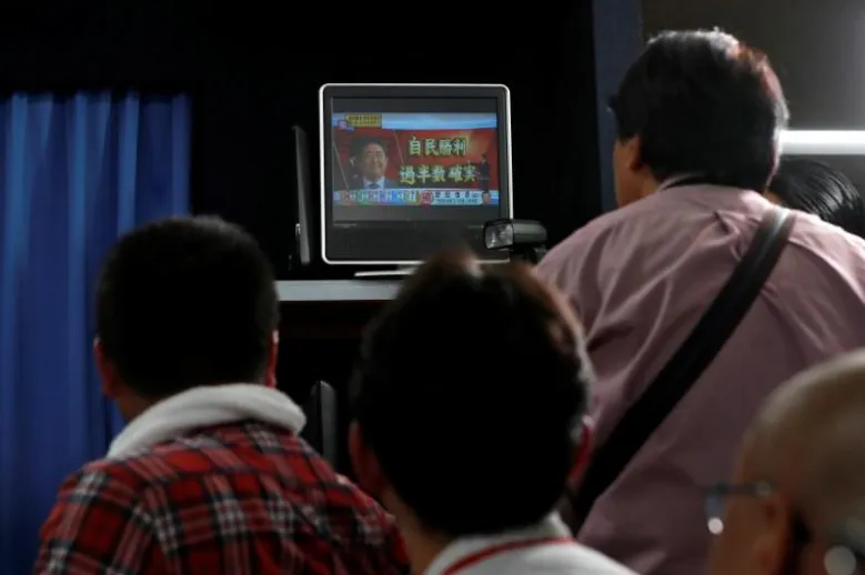 Người dân theo dõi thăm dò kết quả bầu cử Hạ viện Nhật ngày 22-10. Ảnh: REUTERS