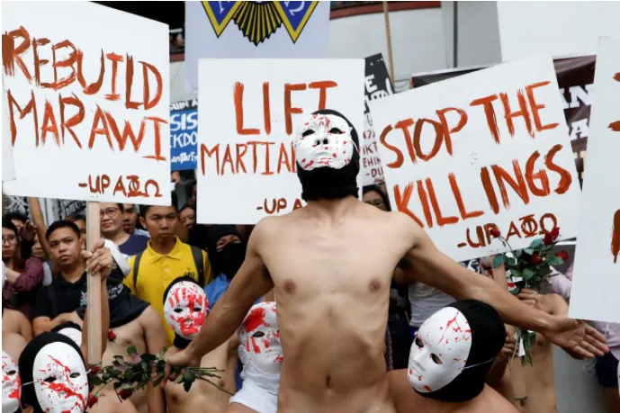 Nam sinh viên Philippines trùm đầu, đeo mặc nạ và khỏa thân biểu tình tại thủ đô Manila ngày 1-12. Ảnh: REUTERS