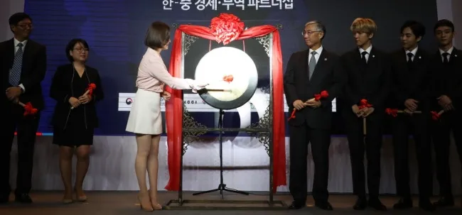 Nữ diễn viên Song Hye-kyo đánh chuông khai mạc sự kiện Đối tác Kinh tế và Thương mại Hàn-Trung tại Bắc Kinh (Trung Quốc) ngày 14-12, cùng Tổng thống Hàn Quốc Moon Jae-in và các thành viên ban nhạc EXO. Ảnh: YONHAP