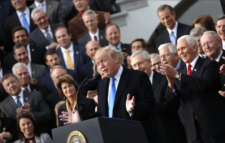 Tổng thống Mỹ Donald Trump (giữa) ăn mừng thực hiện được một cam kết tranh cử lớn: cải cách thuế, tại cuộc họp nội các ở Nhà Trắng ngày 20-12. Ảnh: REUTERS