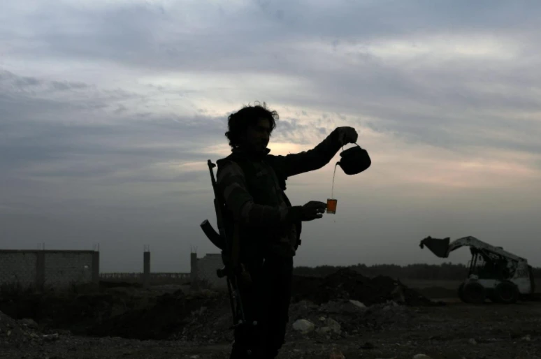 Một tay súng phe nổi dậy uống trà tại thị trấn Dael, gần thủ đô Damacus (Syria) do phe nổi dậy kiểm soát, ngày 22-12. Ảnh: REUTERS