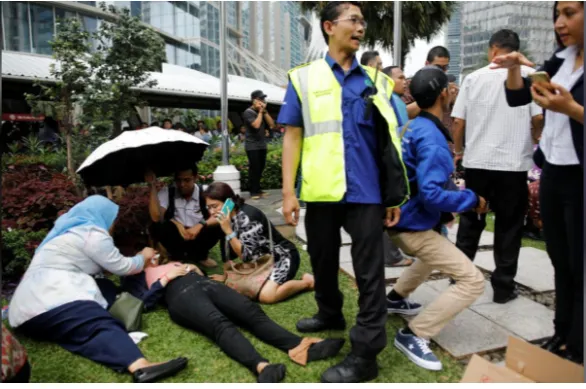 Người bị thương được sơ cứu ngay trên bãi cỏ ngoài sàn chứng khoán, ngày 15-1. Ảnh: REUTERS