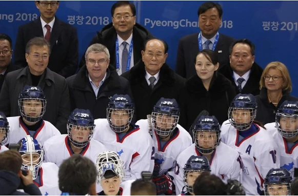 Từ trái sang): Tổng thống Hàn Quốc Moon Jae-in, Chủ tịch Ủy ban Olympic Quốc tế Thomas Bach, ông Kim Yong-nam, bà Kim Yo-jong chụp ảnh cùng đội VĐV liên Triều tại trung tâm khúc côn cầu Kwandong ở TP Gangneung, tỉnh Gangwon. Ảnh: REUTERS