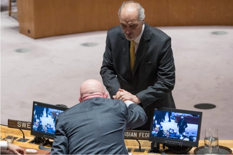 Đại sứ Nga tại LHQ Vassily Nebenzya (đứng quay lưng) bắt tay với đại sứ Syria tại LHQ Bashar al-Jaafari sau cuộc họp HĐBA LHQ về Syria ngày 22-2. Ảnh: AP