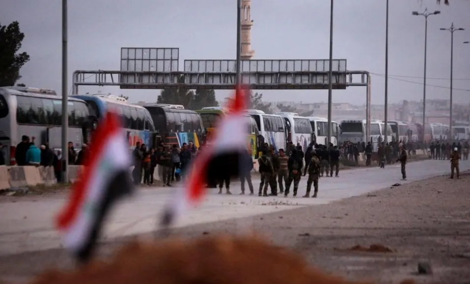 Đoàn xe chở các tay súng nổi dậy và người thân ở thị trấn Harasta, Đông Ghouta, ngoại ô thủ dô Damacus (Syria) ngày 22-3. Ảnh: REUTERS