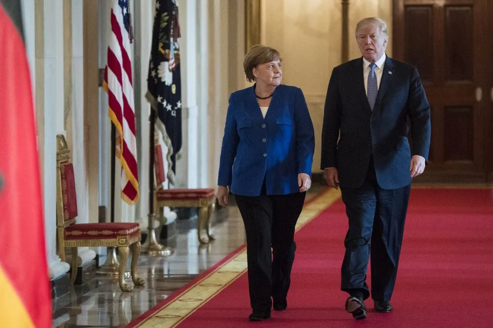 Tổng thống Mỹ Donald Trump (phải) và Thủ tướng Đức Angela Merkel trên đường đến cuộc họp báo sau cuộc hội đàm tại Nhà Trắng ngày 27-4. Ảnh: AP