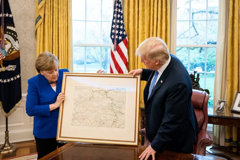 Thủ tướng Đức Angela Merkel tặng quà cho Tổng thống Mỹ Donald Trump trong chuyến thăm ngày 27-4. Ảnh: DW