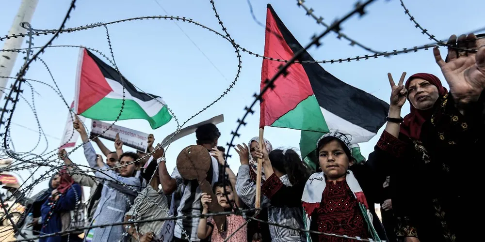 Dân Palestine ở Dải Gaza tiếp cận hàng rào biên giới với Israel trong ngày biểu tình 13-5. Ảnh: REUTERS