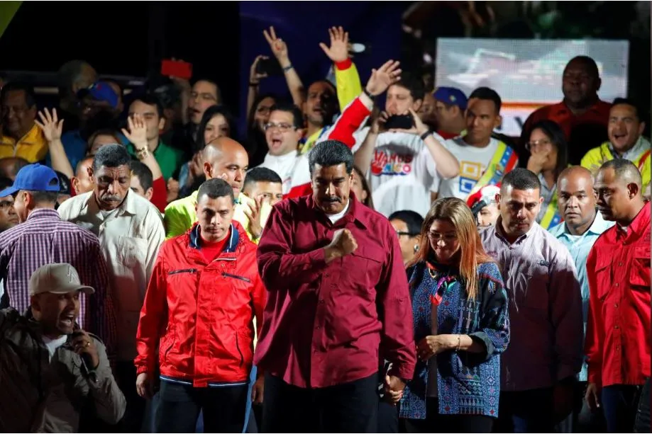Tổng thống Venezuela Nicolas Maduro (giữa) phát biểu trước người ủng hộ sau khi chiến thắng trong cuộc bầu cử ngày 20-5, tại Caracas (Venezuela) tối 20-5. Ảnh: REUTERS
