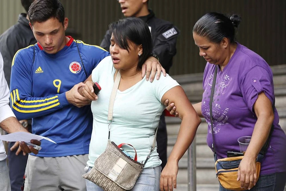 Barbara Barca (giữa), người sống sót trong vụ dẫm đạp vì hơi cay tại hộp đêm rời khỏi trụ sở cảnh sát ở Caracas (Venezuela) ngày 16-6. Ảnh: AP