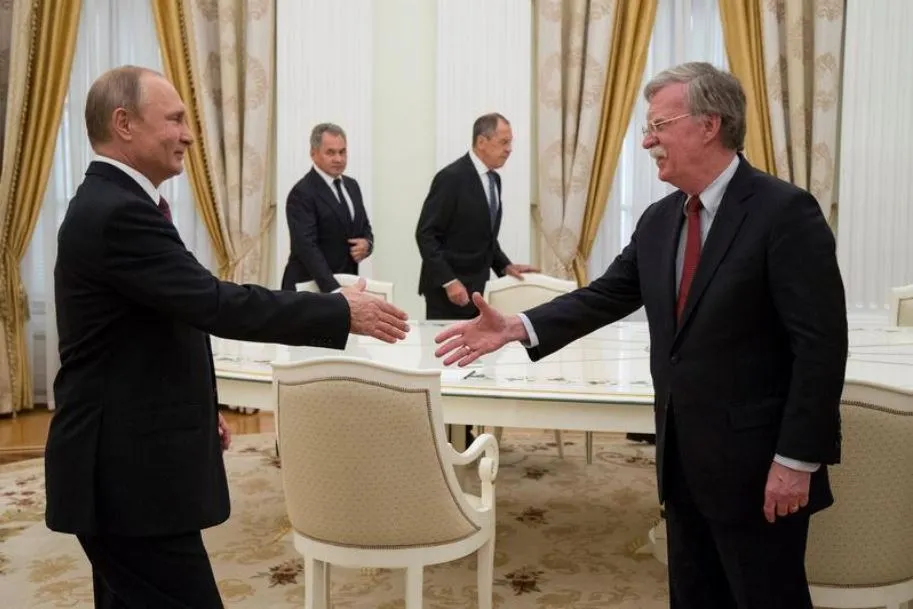 Tổng thống Nga Vladimir Putin (trái) bắt tay Cố vấn an ninh quốc gia Mỹ John Bolton trong cuộc gặp tại Điện Kremlin (Nga) ngày 27-6. Ảnh: REUTERS