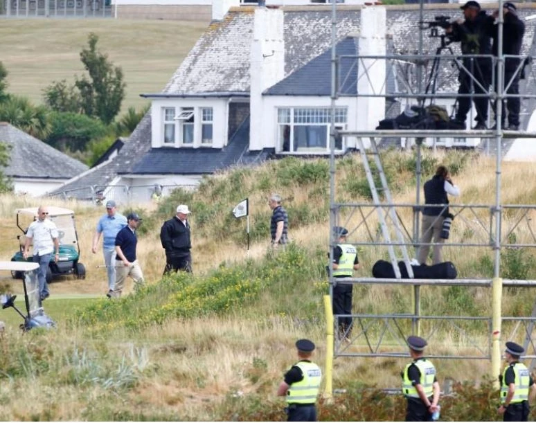 Tổng thống Mỹ Donald Trump (áo khoác đen, nón trắng) tại khu nghỉ dưỡng đánh golf của mình ở Turnberry (Scotland) ngày 14-7. Ảnh: REUTERS