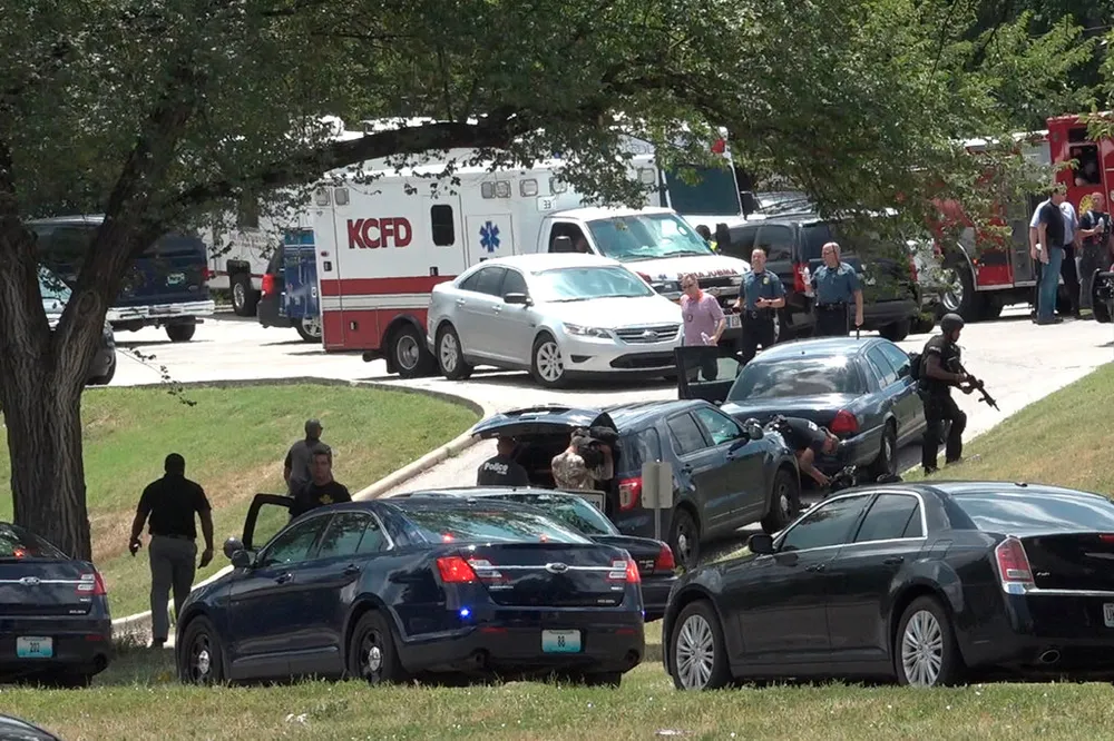 Cảnh sát điều tra tại hiện trường thứ hai của vụ án - giao lộ ở TP Kansas, bang Missouri (Mỹ), nơi tên cướp trốn vào một ngôi nhà sau khi bắn bị thương 2 cảnh sát ngày 15-7. Ảnh: AP