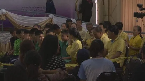 Các cậu bé ngồi cùng bố mẹ trước thời điểm bắt đầu họp báo. Ảnh: APTN