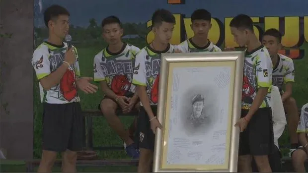 Các cậu bé và bức di ảnh cựu đặc nhiệm Thai Navy Seals Saman Kunan tại cuộc họp báo. Ảnh: REUTERS