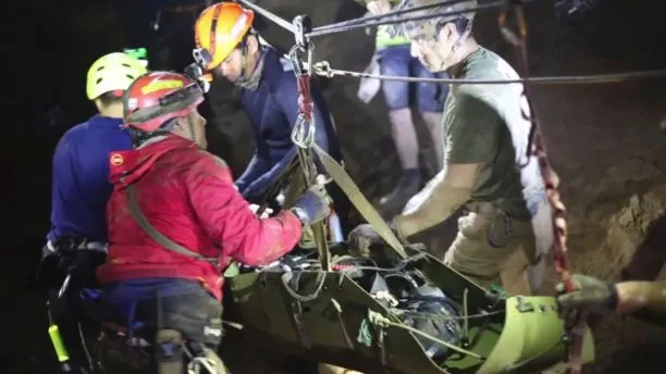 Một cậu bé được đưa lên cáng di chuyển qua đoạn không ngập nước trong hang động Tham Luang. Ảnh: THAI NAVY SEALS